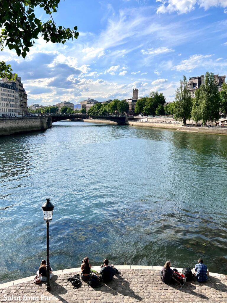 Seine in paris with teenagers relaxing at the banks