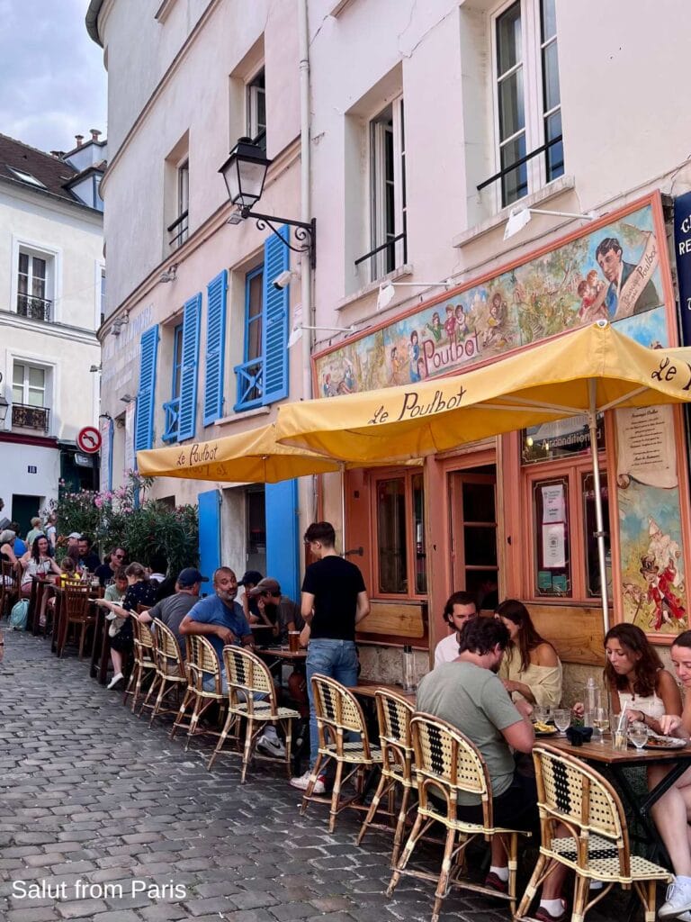 Outdoor terrace dining at Le Poulbot in Montmartre on a summer evening