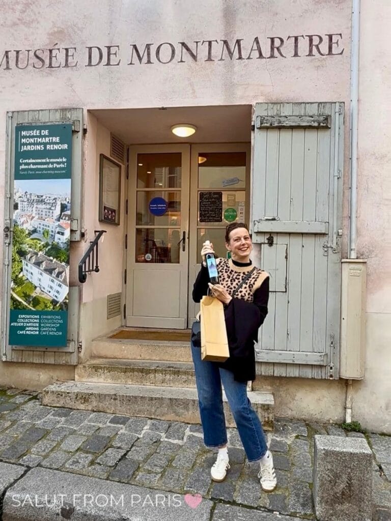Lena with a bottle of Montmartre Wine in front of the Musée de Montmartre