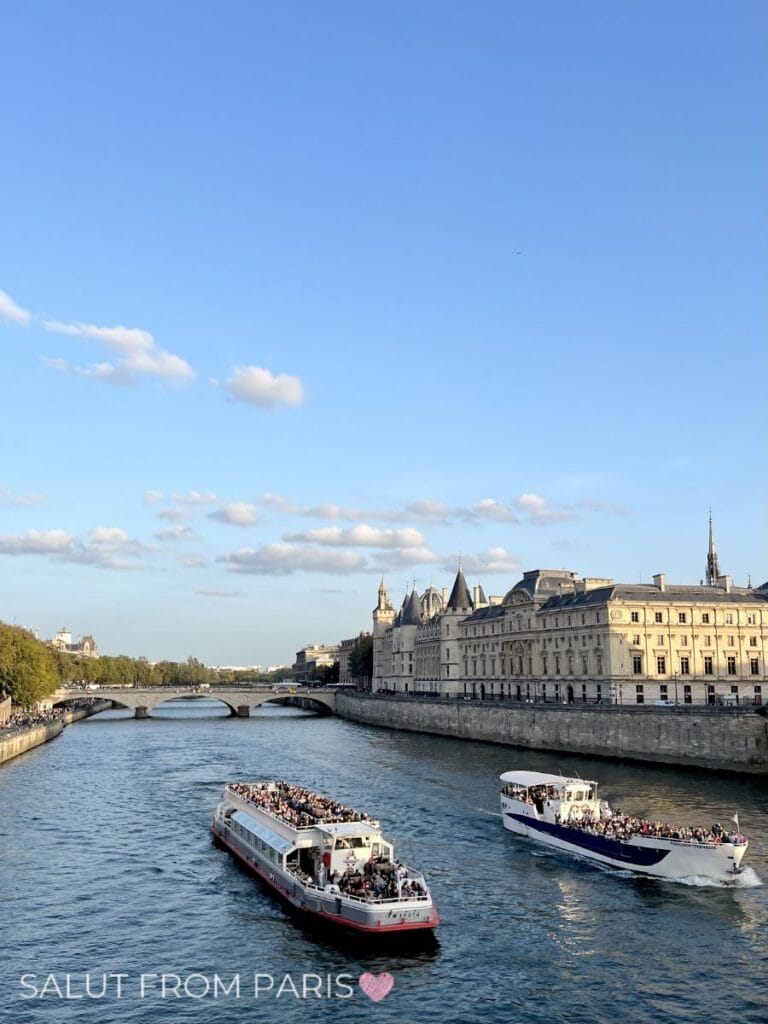 is a seine cruise worth it? It is easy to decide when seeing here on this picture Two crowded sightseeing boats pass each other on the Seine with passengers seated on open decks, framed by grand historic architecture and a low arched bridge. The lively river traffic reflects the popularity of the best Seine cruise in Paris.