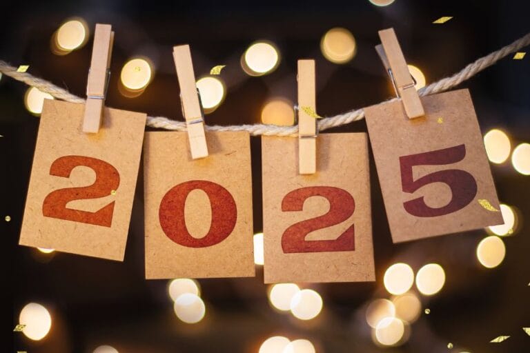 This festive image celebrates New Year 2025, featuring four brown paper cards clipped to a rope with clothespins, each displaying a bold red number forming "2025." The background is illuminated with warm golden bokeh lights, creating a cozy and celebratory atmosphere. Small golden confetti pieces float in the air, enhancing the sense of joy and anticipation for the new year. The rustic yet elegant design makes it a perfect New Year's greeting or decoration for welcoming 2025 in style.