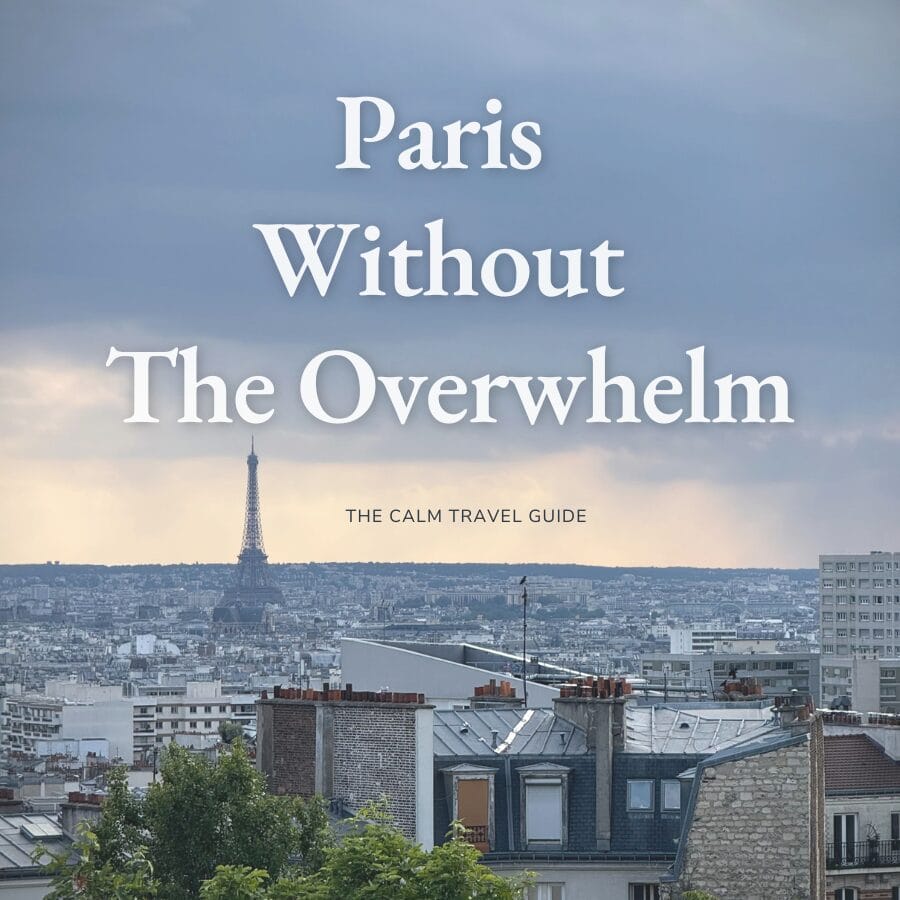 Cover image for a travel guide titled “Paris Without The Overwhelm” with the subtitle “The Calm Travel Guide.” The Eiffel Tower rises above the Paris skyline beneath dramatic gray clouds, with rooftops and apartment buildings filling the foreground.